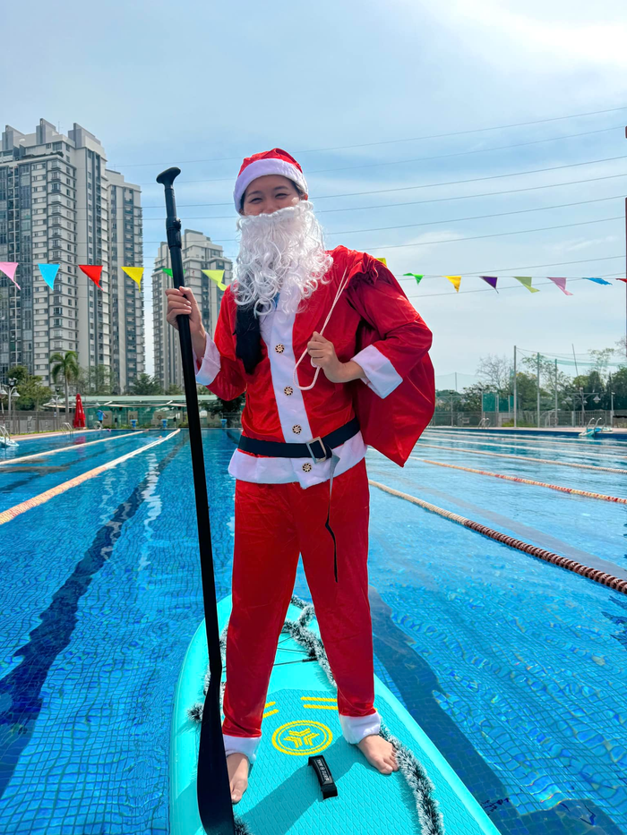 Ánh Viên đứng trên ván chèo cùng tạo hình ông già Noel mang theo túi quà. Trên ván còn được trang trí thêm dây tuyết tạo không khí Giáng Sinh. 