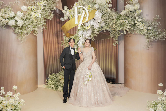 Anh Đức và Anh Phạm cười rạng rỡ, 'tay trong tay' trong không gian đám cưới tràn ngập hoa tươi hồi tháng 6 năm nay. (Ảnh: FBNV)