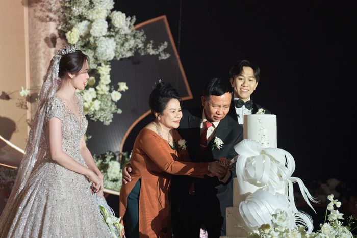 Cả hai ghi điểm khi để bố mẹ cắt bánh kem cưới vì ngày diễn ra lễ cưới trùng với sinh nhật của bố Anh Đức.