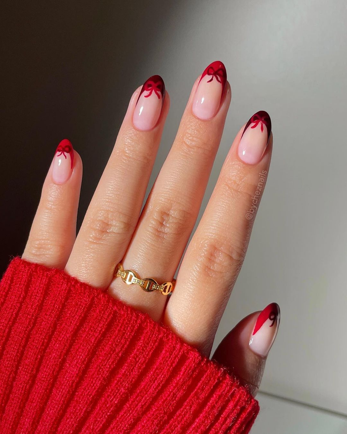 Màu nails đỏ luôn được là 'biểu tượng' của dịp lễ hội cuối năm. Kiểu nails french đầu móng sẽ giúp bàn tay của bạn trở nên có điểm nhấn, hãy thêm một vài cái nơ để trong có không khí Giáng Sinh hơn. 