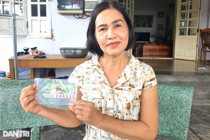 Bà N. cầm trên tay tờ vé số trúng độc đắc nhưng không được trả thưởng. Ảnh: Dân Trí