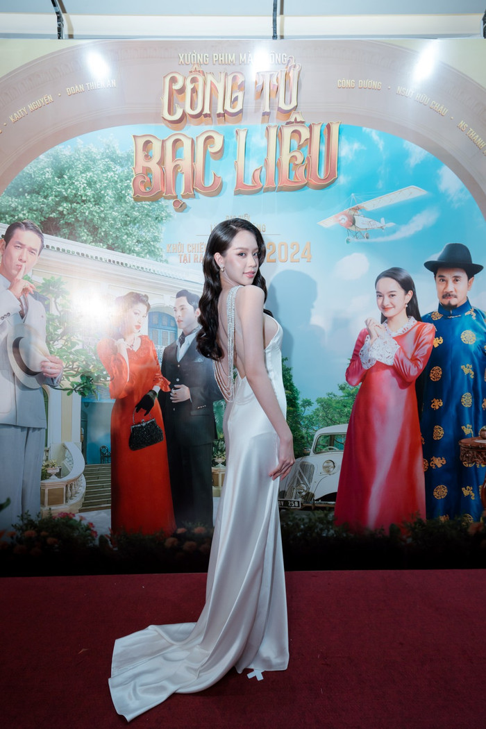 Hoa hậu Thanh Thủy đốt mắt người xem khi diện đầm lụa khoe trọn tấm lưng ngọc ngà. Phần thân váy được kết thêm chuỗi ngọc trai sang trọng. Thanh Thủy làm tóc và trang điểm theo phong cách cổ điển, khoe nụ cười tỏa nắng. Dân tình giục cô nàng tham gia ngay một bộ phim xưa vì quá hợp 'vibe'.