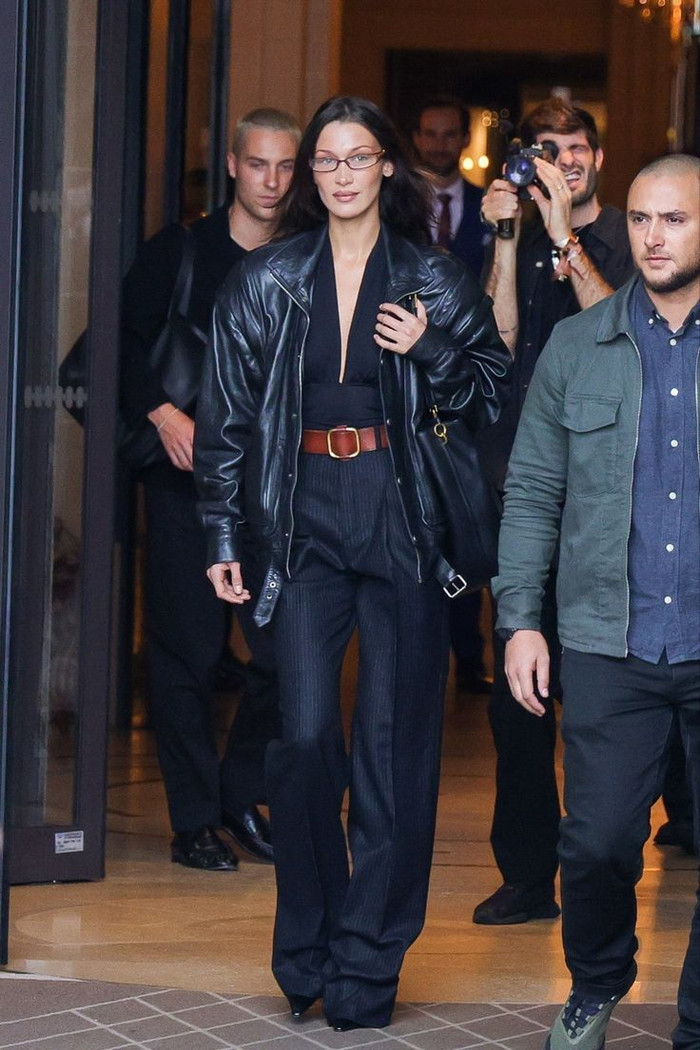 Nếu cần một diện mạo lịch sự nhưng vẫn thể hiện được 'trình' phối đồ, hãy nhìn Bella Hadid. Trong hình, thiên thần Victoria's Secret diện quần tây ống loe nhẹ kết hợp áo thun xẻ ngực và áo khoác da. Mỹ nhân không quên nhấn nhá cho tổng thể bằng một chiếc thắt lưng bản to màu nâu. 