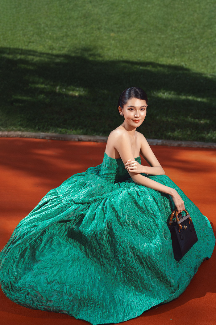 Á Hậu Thùy Dung đẹp thanh lịch trong đầm ống dáng xòe babydoll quyến rũ, cô xách thêm túi cầm tay đen bằng da đến từ Gucci. 