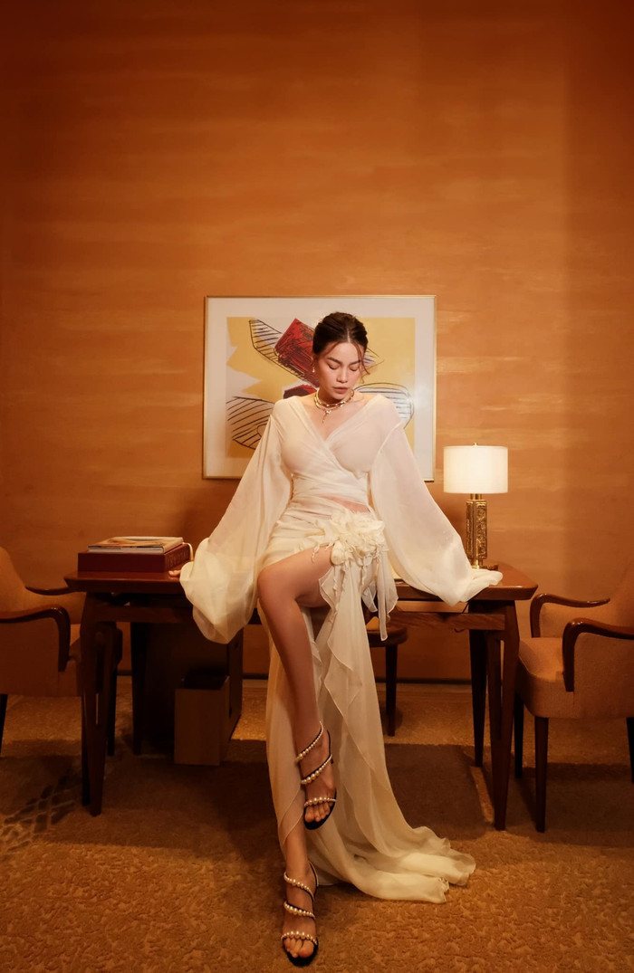 Kết hợp với áo, Hồ Ngọc Hà diện thiết kế váy bất đối xứng có tà tua rua nhấn thêm hoa nổi bên hông tạo cảm giác nữ tính, điệu đà. Bà xã Kim Lý mang thêm giày cao gót màu đen có chi tiết ngọc trai quấn quanh chân làm tăng độ sang chảnh. 