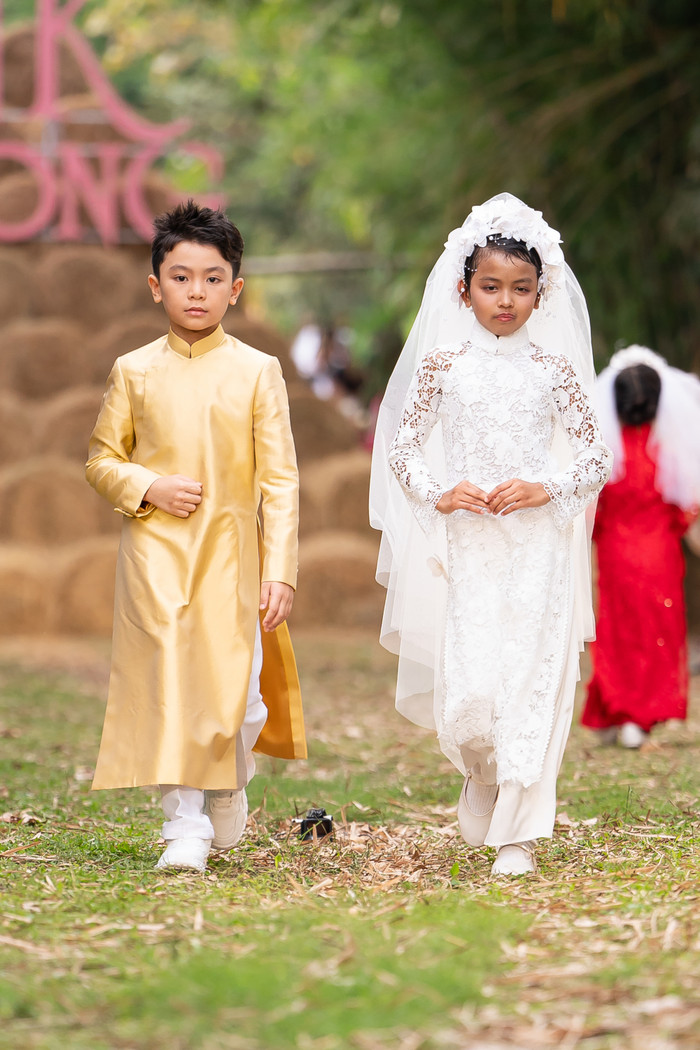 Gam màu chủ đạo của bộ sưu tập là sắc trắng thanh khiết, điểm xuyết thêm hồng, vàng, xanh, đỏ – gợi nên sự rực rỡ nhưng vẫn nền nã. Đặc biệt, phụ kiện như nón cụ quai cung, được chế tác kỳ công bởi nghệ nhân cao tuổi, là minh chứng cho sự trân trọng giá trị truyền thống.'Tơ Lụa Giao Thời' không chỉ là thời trang, mà còn là một câu chuyện văn hóa, một nhịp cầu nối giữa quá khứ và hiện tại. 