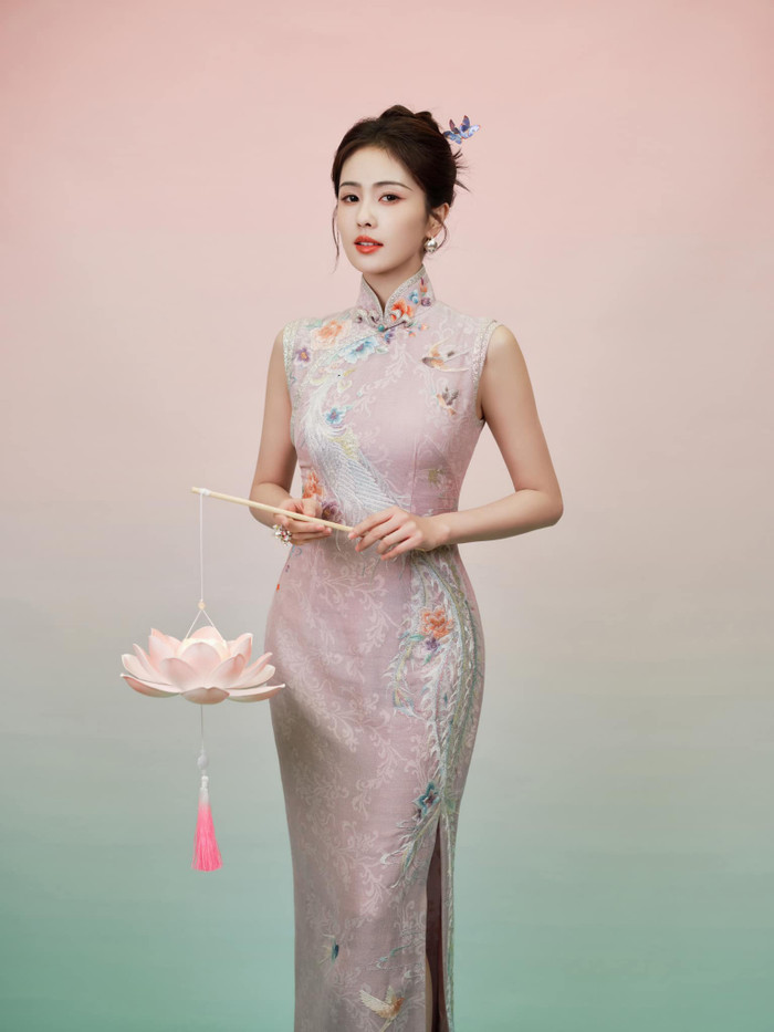 Trong bộ ảnh vừa được phòng làm việc chia sẻ, Bạch Lộc diện sườn xám sáng màu, hoạ tiết con công, được tô điểm bởi nhiều mảng hoa rực rỡ.