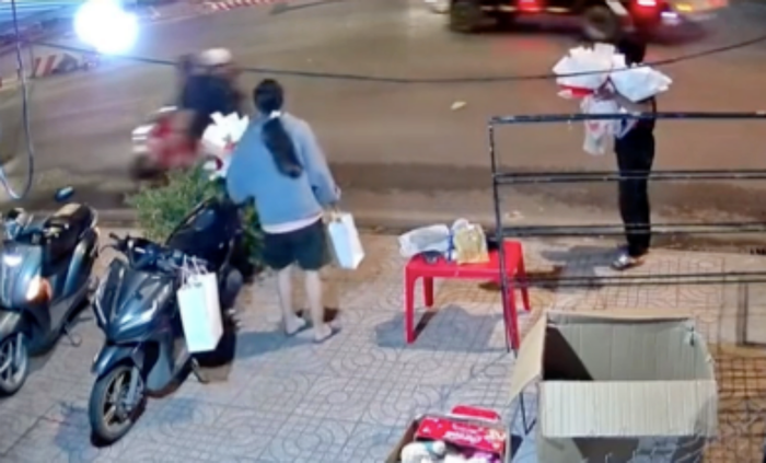 Hai người chủ tiêm hoa ngỡ ngàng sau khi cô gái ôm hoa, nam thanh niên vít ga bỏ đi không trả tiền. (Ảnh chụp màn hình clip).