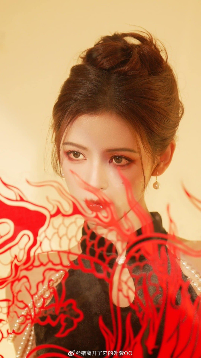 Trương Dư Hi là một trong những sao nữ mặc ấn tượng nhất dịp Tết năm nay. Cô diện yếm cách điệu màu đen, khoe vai trần quyến rũ. Bên cạnh hoạ tiết hình rồng đẹp mắt, Trương Dư Hi còn kết hợp thêm trang sức ngọc trai làm tăng thêm phần sang trọng. Kiểu trang điểm sắc sảo của nữ diễn viên gây sốt, được ví như 'búp bê sống' của Cbiz.