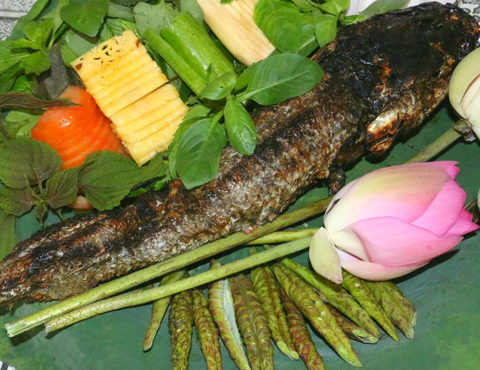 Cá lóc được nướng vàng giòn, ăn kèm với các loại rau sống