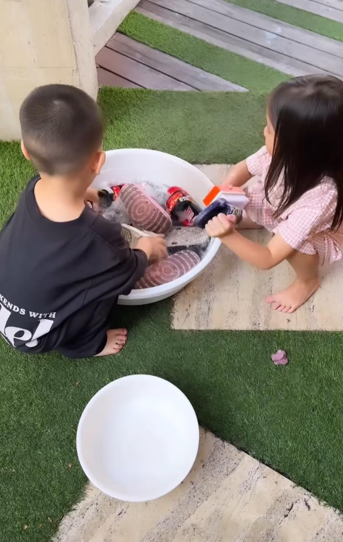 Cặp song sinh Leon - Lisa phụ mẹ giặt giày dép.