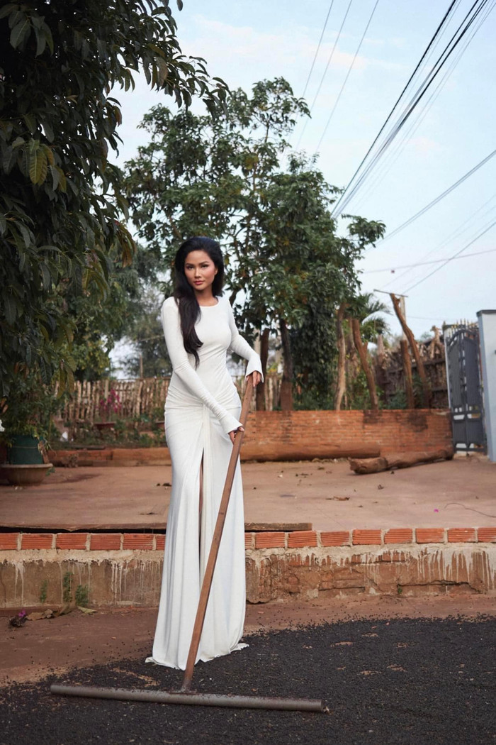 H'Hen Niê mặc váy trắng đầy thanh lịch, quyến rũ nhưng lại tranh thủ phơi hạt tiêu. Ảnh: Facebook Đỗ Long