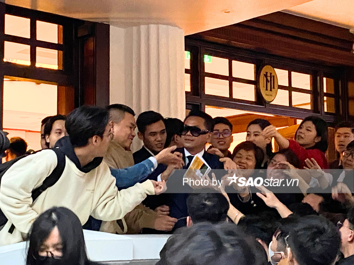 NTK Thái Công cố gắng đưa thêm giấy có chữ ký cho người hâm mộ trước khi tiến vào khách sạn nghỉ ngơi.