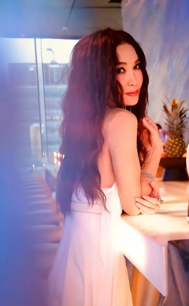Nữ diễn viên mải mê chụp hình mà không để ý những ngọn nến đặt trên chiếc bàn pha chế phía sau.