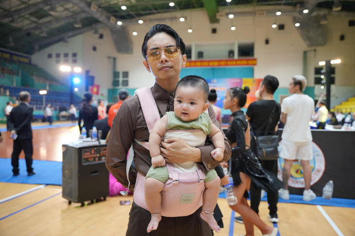 Dù lên đồ sang chảnh với những bộ suit thẳng thớm, thanh lịch, chồng Khánh Thi vẫn không ngần ngại đeo địu con gái út. Ảnh: FBNV