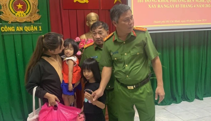 Đại tá Nguyễn Hải Phước, Trưởng Công an quận 1 và đại diện Phòng Cảnh sát hình sự, Công an TPHCM bàn giao 2 bé cho mẹ.