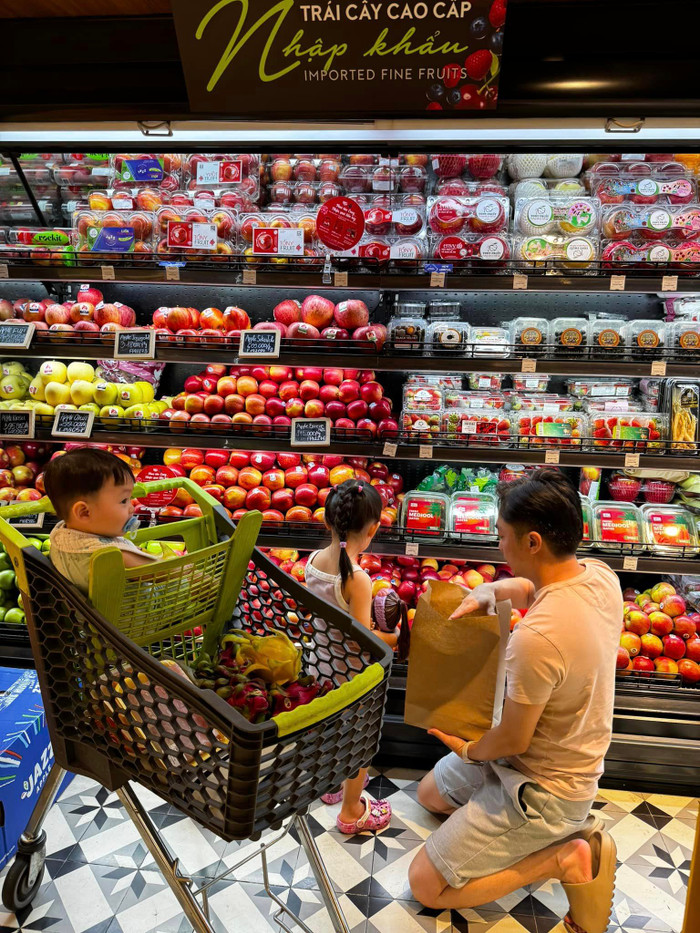 Cường Đô La không ngần ngại cúi xuống để chọn hoa quả cùng con gái Suchin. Ảnh: FBNV