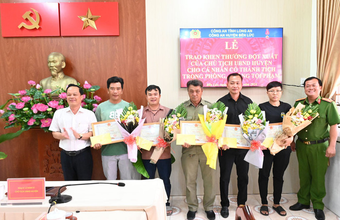 Chủ tịch UBND huyện Bến Lức (áo trắng) động viên, khen thưởng nóng cho dân phòng khu phố và 4 người dân. Ảnh: VietNamNet