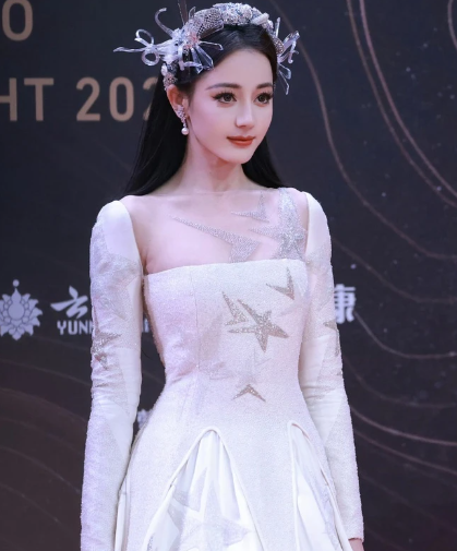 Hai hàng lông mi giả dày quá khổ khiến đôi mắt vốn sắc sảo của Địch Lệ Nhiệt Ba trở nên nặng nề.