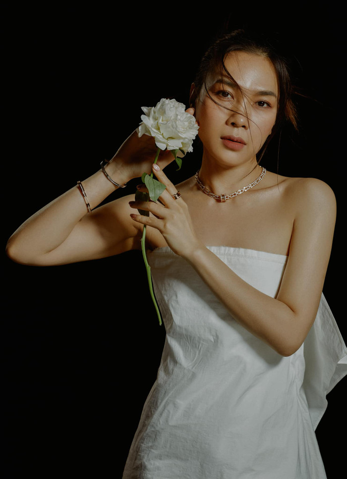 Không diện váy áo lồng lộn, chói lọi, Mỹ Tâm chỉ quấn chiếc khăn trắng thành mẫu váy cúp ngực. Nữ ca sĩ để lộ bờ vai trần nuột nà, mịn màng và không một chút khuyết điểm. Để tổng thể thêm phần ấn tượng, Mỹ Tâm còn kết hợp cùng vòng vay, vòng cổ màu đồng, thiết kế mảnh mai tạo điểm nhấn.