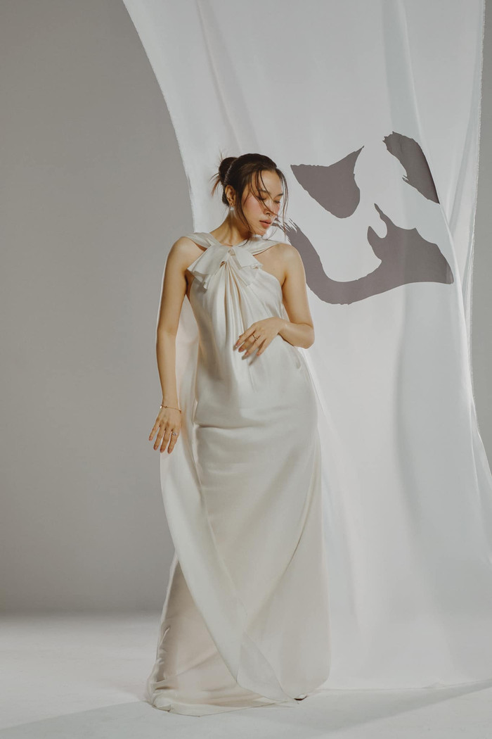 Trong một khoảnh khắc khác, Mỹ Tâm diện mẫu váy lụa dài trắng bồng bềnh, thiết kế cổ yếm. Nữ ca sĩ tự tin thả dáng trước ống kính. Từng pose dáng của Mỹ Tâm đều 'ăn điểm' vì sự gãy gọn, mượt mà cùng thần thái, khí chất tựa một 'đại minh tinh'.