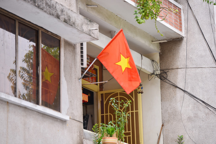 Những lá cờ đỏ sao vàng tung bay trong nắng được treo ở một tòa nhà chung cư tại TPHCM.