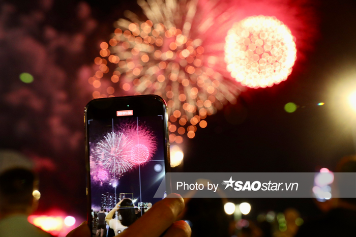 Nhiều người dân dùng điện thoại, máy ảnh để ghi lại khoảnh khắc pháo hoa trên bầu trời TPHCM mừng 49 năm Ngày Giải phóng miền Nam, thống nhất đất nước (30/4/1975 - 30/4/2024)
