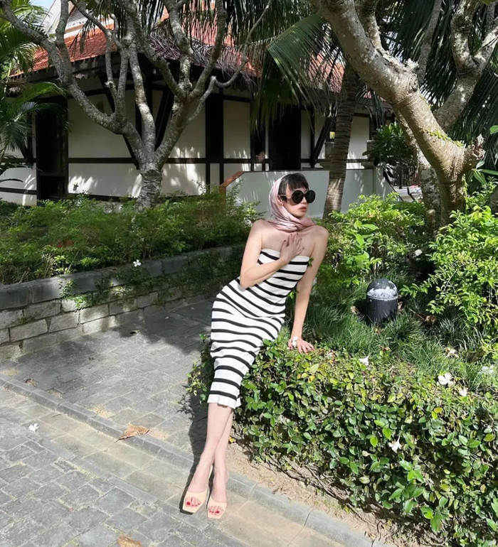 Trong một chuyến đi du lịch, bà Mai Đoàn chọn lựa chiếc váy cúp ngực màu trắng sọc ngang đen. Bà còn khéo léo kết hợp cùng dép bệt, khăn dội đầu cùng chiếc kính râm đen.