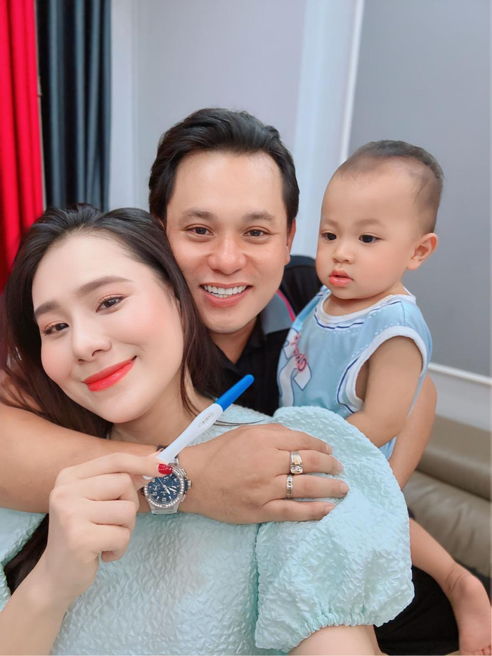 Hồ Bích Trâm hạnh phúc khoe que thử thai hiện hai vạch, chồng và con trai của nữ diễn viên đều lộ rõ biểu cảm vui mừng. Ảnh: FBNV
