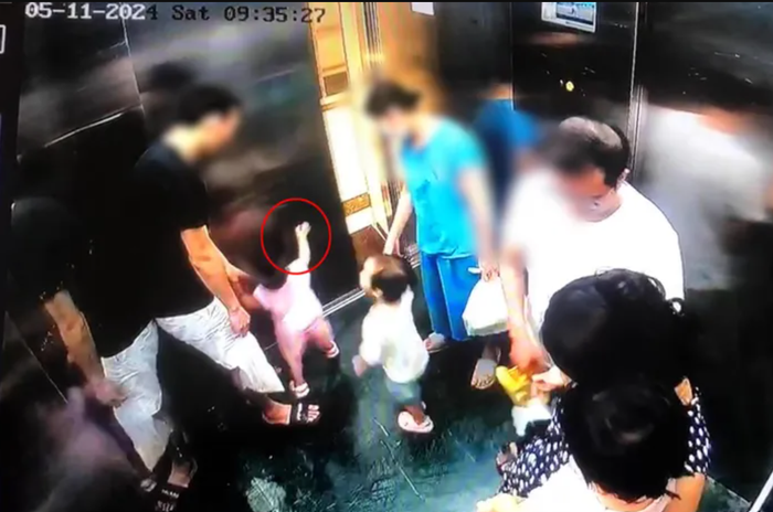 Em bé liên tục nghịch cánh cửa thang máy. 