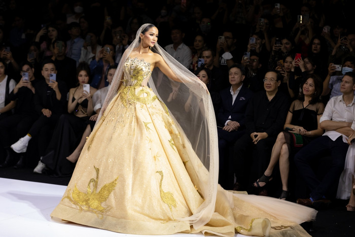 Lại một lần nữa H'Hen Niê hóa công chúa trong trang phục cưới từ NTK Linh San. Được biết thiết kế có trọng lượng 15kg. Bộ trang phục gây ấn tượng với màu vàng bắt mắt, cùng những họa tiết chim cò được thêu trực tiếp lên váy tạo nên hiệu ứng cực kỳ mãn nhãn cho người xem.