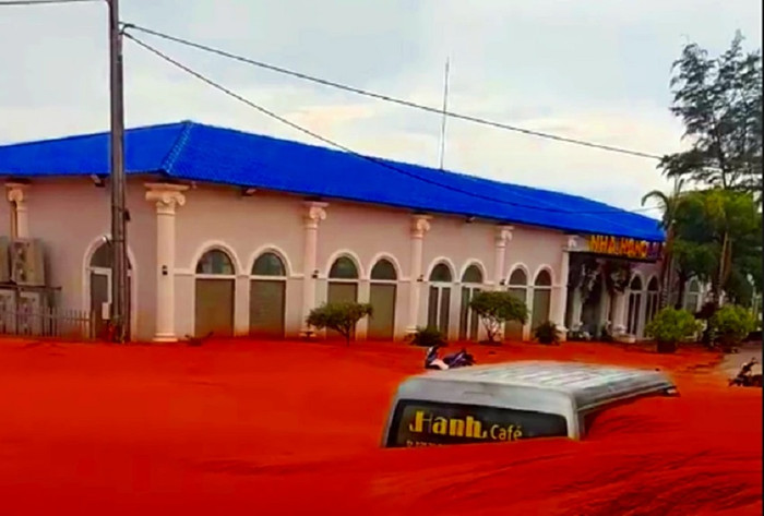 Một nhà hàng, một chiếc ô tô bị cát đỏ 'nhấn chìm'. Ảnh: PLO