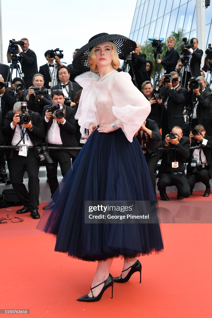 Elle Fanning hoá thân thành một công nương với chiếc váy xoè rộng, áo sơ mi bồng bềnh cách điệu cùng nón rộng vành.