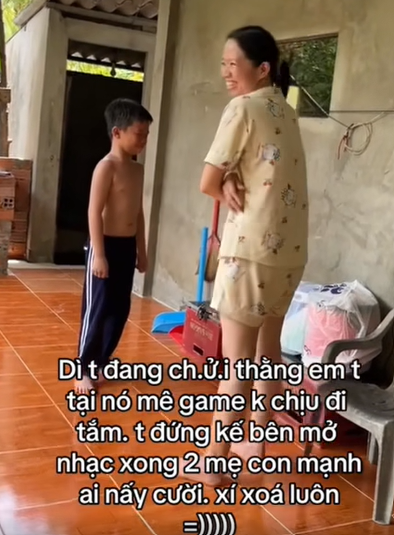 Người dì và cậu nhóc đang căng bỗng nhiên bật cười vì giai điệu bài hát.