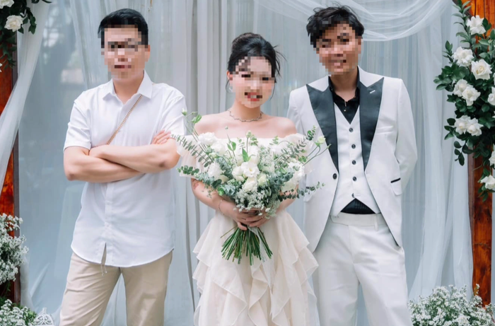 Cô gái mặc váy trắng, cầm hoa cưới, bị nhầm là cô dâu.