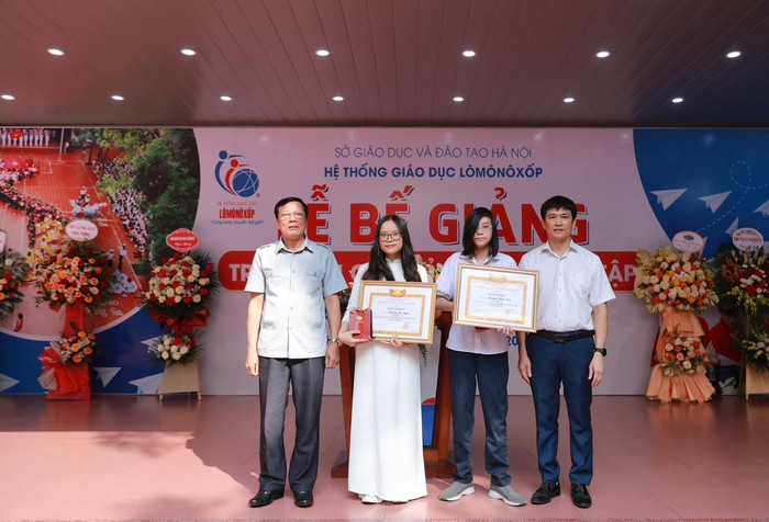 Đại diện nhà trường tặng giấy khen và phần thưởng đặc biệt cho hai học sinh tiêu biểu.