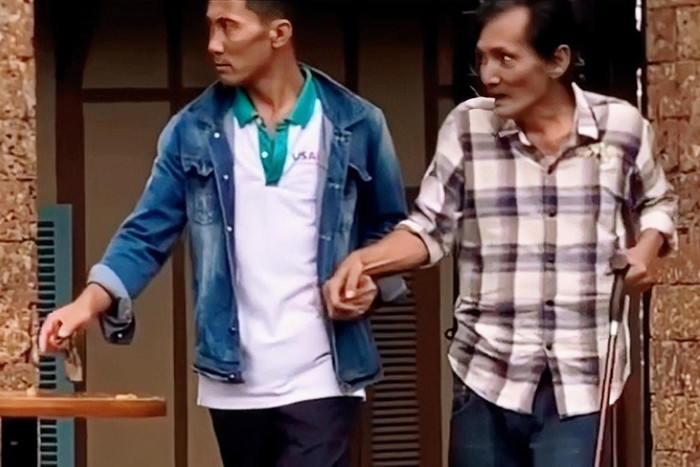 Hình ảnh Thương Tín chống gậy được người khác dìu khiến dân mạng xót xa.