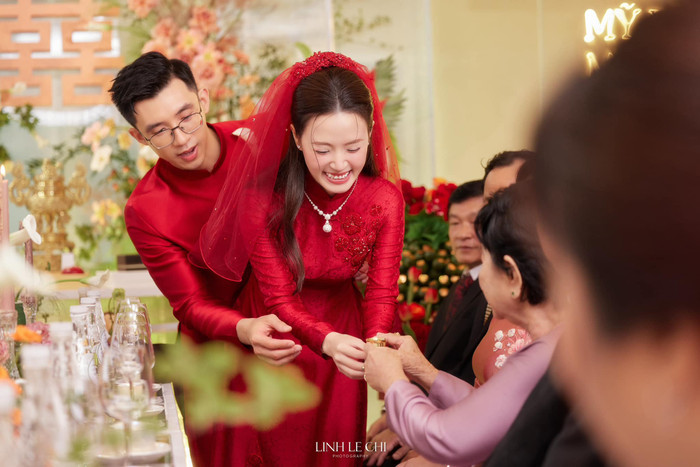 Trong ngày trọng đại, Midu chọn diện chiếc áo dài sắc đỏ rực rỡ trông vừa truyền thống vừa mang nét hiện đại để sánh đôi bên bạn trai thiếu gia.