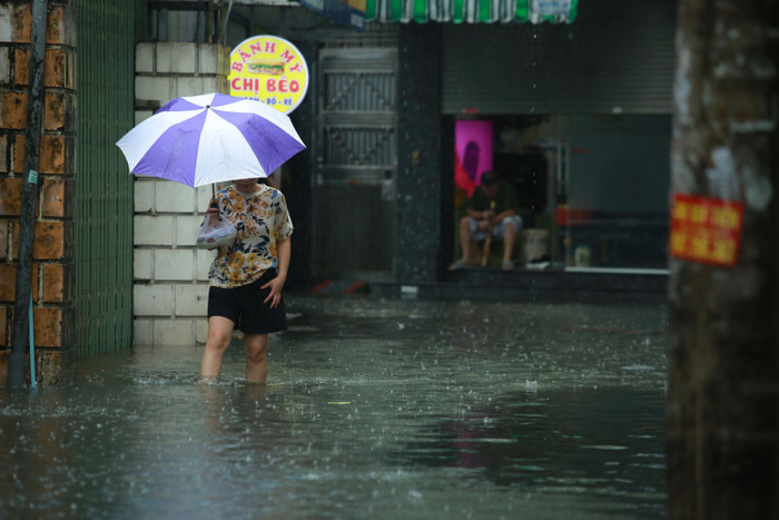 Người dân lội nước sau cơn mưa lớn.