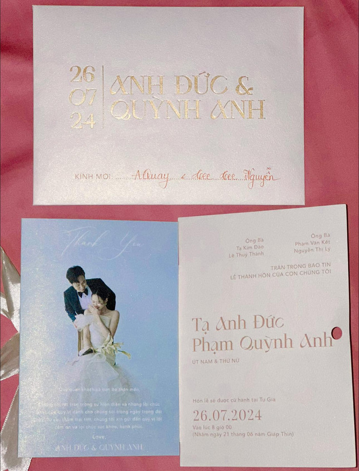 Thiệp cưới của Anh Đức và Quỳnh Anh với tông màu trắng, hồng chủ đạo. 