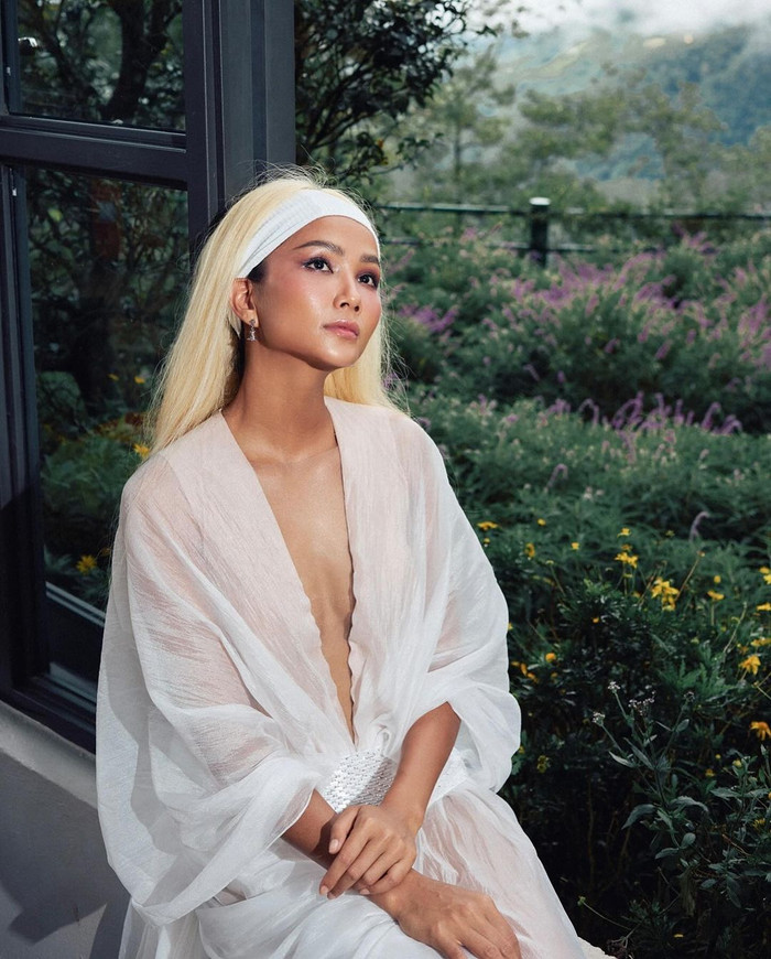 Ở góc chụp 1/2, người đẹp khoe sắc vóc trong mẫu áo cách điệu nhuộm tông trắng tinh khôi. Nàng hậu gây ấn tượng với mái tóc màu bạch kim cùng lớp trang điểm trong suốt nhẹ nhàng. Không cầu kì, cô sử dụng băng đô nửa đầu giúp cố định và vào nếp phần chân tóc. Có thể thấy, H'Hen Niê cũng tối giản đáng kể trong khâu chọn phụ kiện. &nbsp;