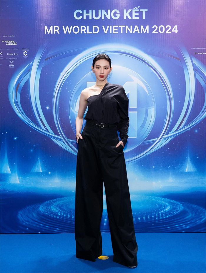 Trung thành với xu hướng monochrome, Thùy Tiên khoác lên mình mẫu áo kiểu trễ vai bất đối xứng Asymmetric được Dior trình làng với giá 60 triệu đồng. Phối cùng, cô diện mẫu quần cotton ống suông Flared Cotton Gabardine có giá 57 triệu đồng. Tăng độ thời thượng, nàng hậu sắm thêm chiếc túi khóa mạ vàng Lady D-sire phiên bản lớn được bán với 185 triệu đồng. Trọn bộ phụ kiện dây chuyền, hoa tai, lắc tay vàng của thương hiệu cũng góp phần tô điểm vẻ ngoài của cô. &nbsp;