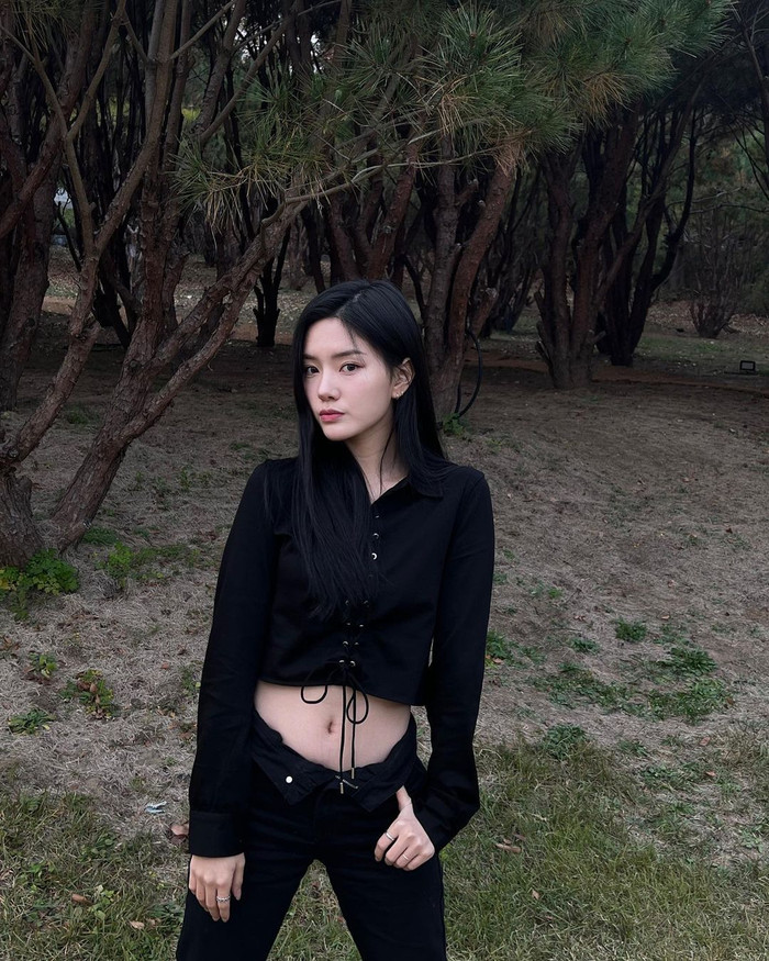 Sự yêu thích sắc đen huyền bí còn được người đẹp ứng dụng trong mỗi dịp du lịch. Rayeon khoe triệt vóc dáng với dáng áo sơ mi croptop rút dây cách điệu. Vòng eo “con kiến” của cô được tôn lên nổi bật nhờ chi tiết bản lật lưng quần độc đáo.  