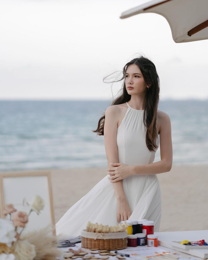 Tham dự ngày vui của anh trai, Thanh Giang chọn cho mình mẫu váy trơn cách điệu cổ yếm nhuộm tông trắng sang trọng. Chất liệu mềm mại, thả rũ kết hợp đường may tinh tế giúp tôn lên hình thể người mặc. 