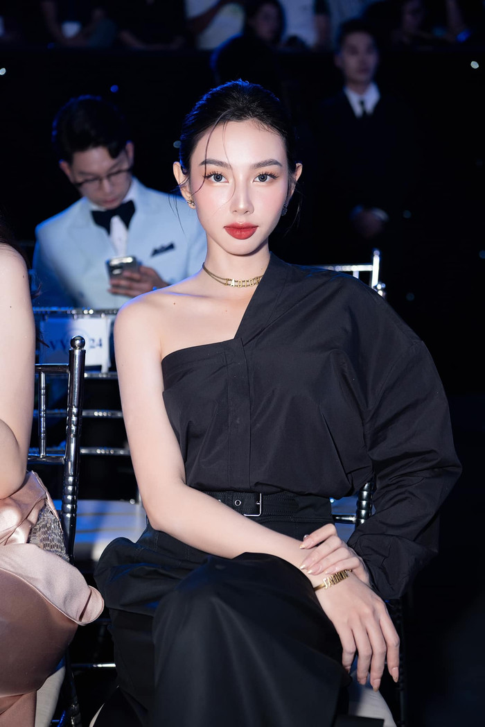 Dù diện đồ cũ, song, Hoa hậu Thùy Tiên vẫn trở thành tâm điểm thảm đỏ chung kết Mr World Vietnam 2024. Là người đẹp thường xuyên thử sức với các màu sắc khác nhau, nàng hậu khiến khán giả thích thú khi ướm bản phối mang hơi hướm menswear đầy cá tính. Thùy Tiên ưu ái diện mẫu áo kiểu trễ vai bất đối xứng Asymmetric được Dior trình làng với giá 60 triệu đồng. Đồng diệu, cô chọn mẫu quần cotton ống suông Flared Cotton Gabardine có giá 57 triệu đồng. Trong khung ảnh toàn cảnh, nàng hậu trình làng mẫu túi khóa mạ vàng Lady D-sire phiên bản lớn được bán với 185 triệu đồng. Trọn bộ phụ kiện dây chuyền, hoa tai, lắc tay vàng của thương hiệu cũng góp phần tô điểm vẻ ngoài của cô.  