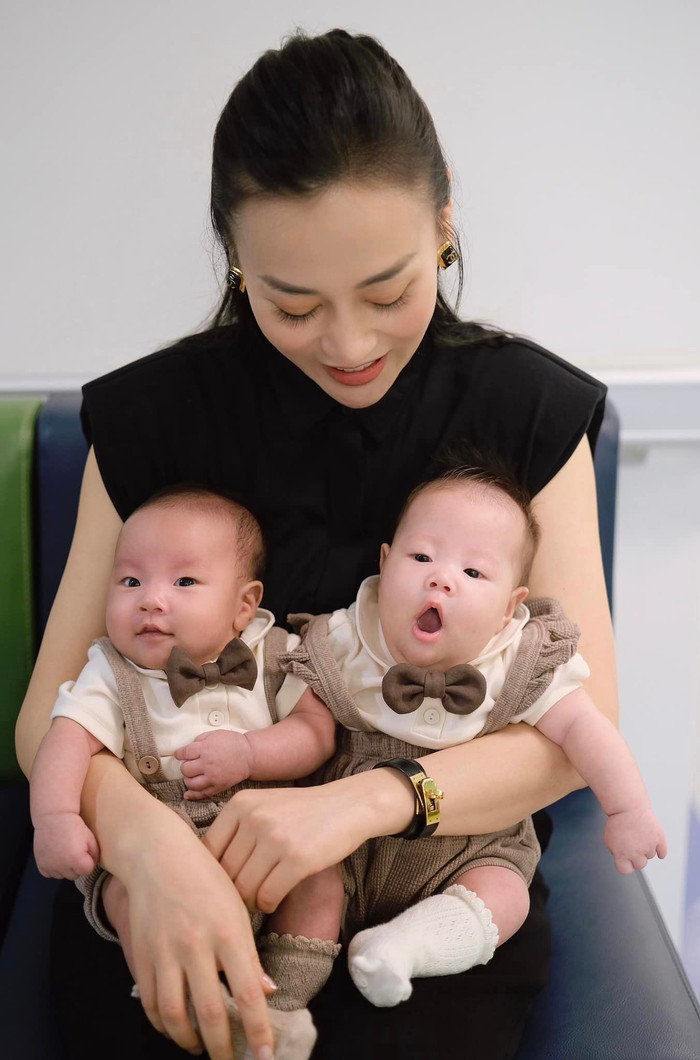 Phương Oanh rạng rỡ bên cạnh cặp song sinh Jimmy và Jenny khi đi tiêm ngừa.