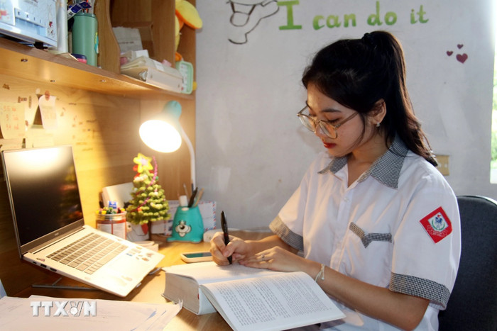 Quỳnh Anh làm bài thi môn Văn với 12 trang giấy. Ảnh: TTXVN