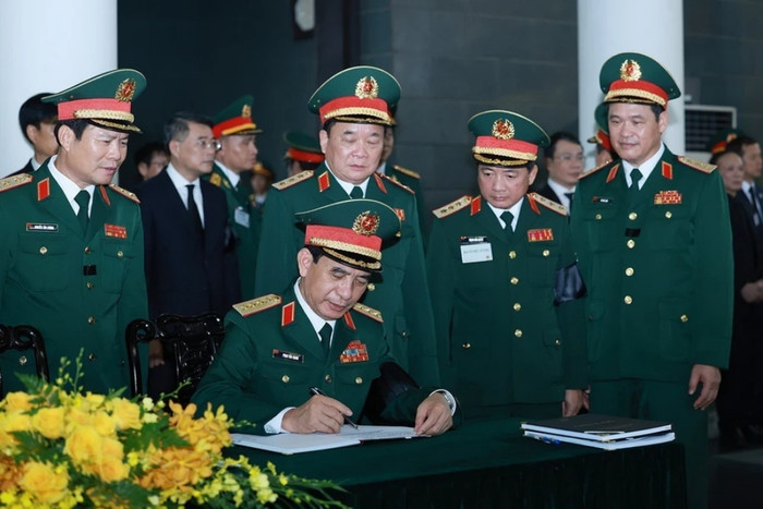 Đại tướng Phan Văn Giang, Phó Bí thư Quân uỷ Trung ương, Bộ trưởng Bộ Quốc phòng ghi sổ tang. (Ảnh: TTXVN)