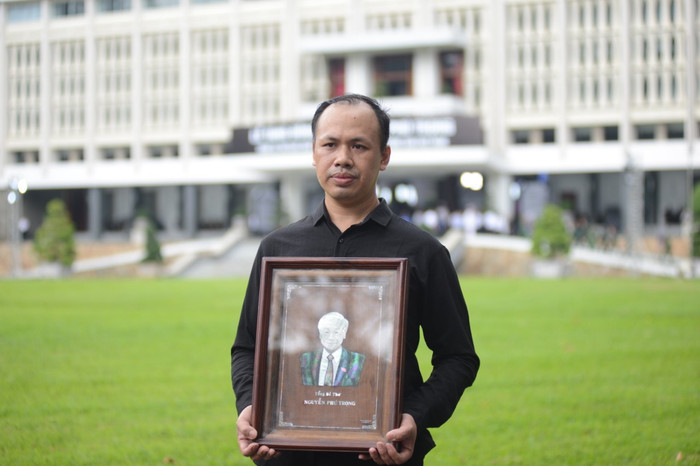 Anh Nguyễn Phú Huỳnh, quê huyện Phú Xuyên, Hà Nội cầm di ảnh Tổng Bí thư đến viếng.