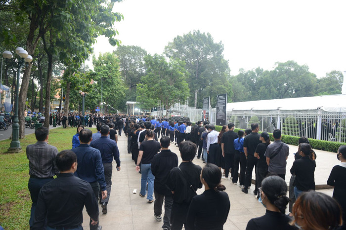 Dòng người mặc áo tối màu xếp hàng dài tại vỉa hè đường Nam Kỳ Khởi Nghĩa trong sáng 26/7.